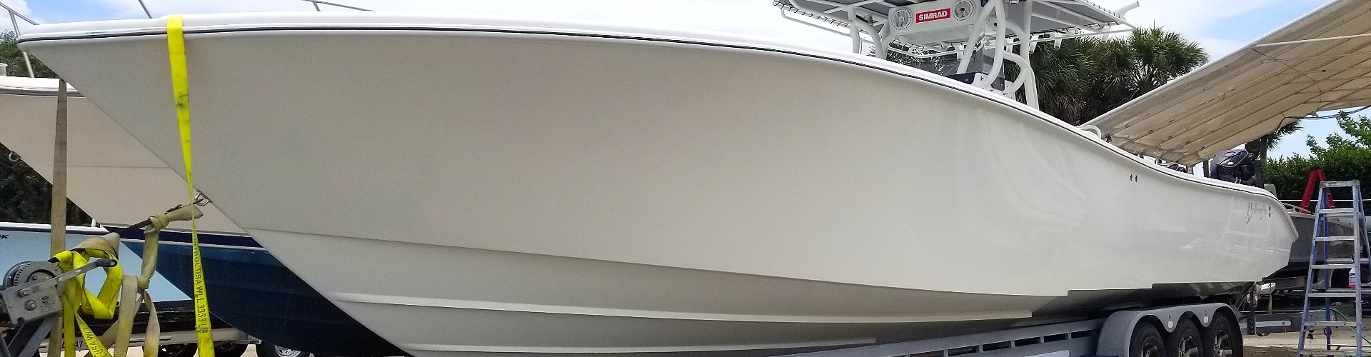  A boat lifted onto a trailer is prepared by Marine Kings of Miami with boat maintenance services.