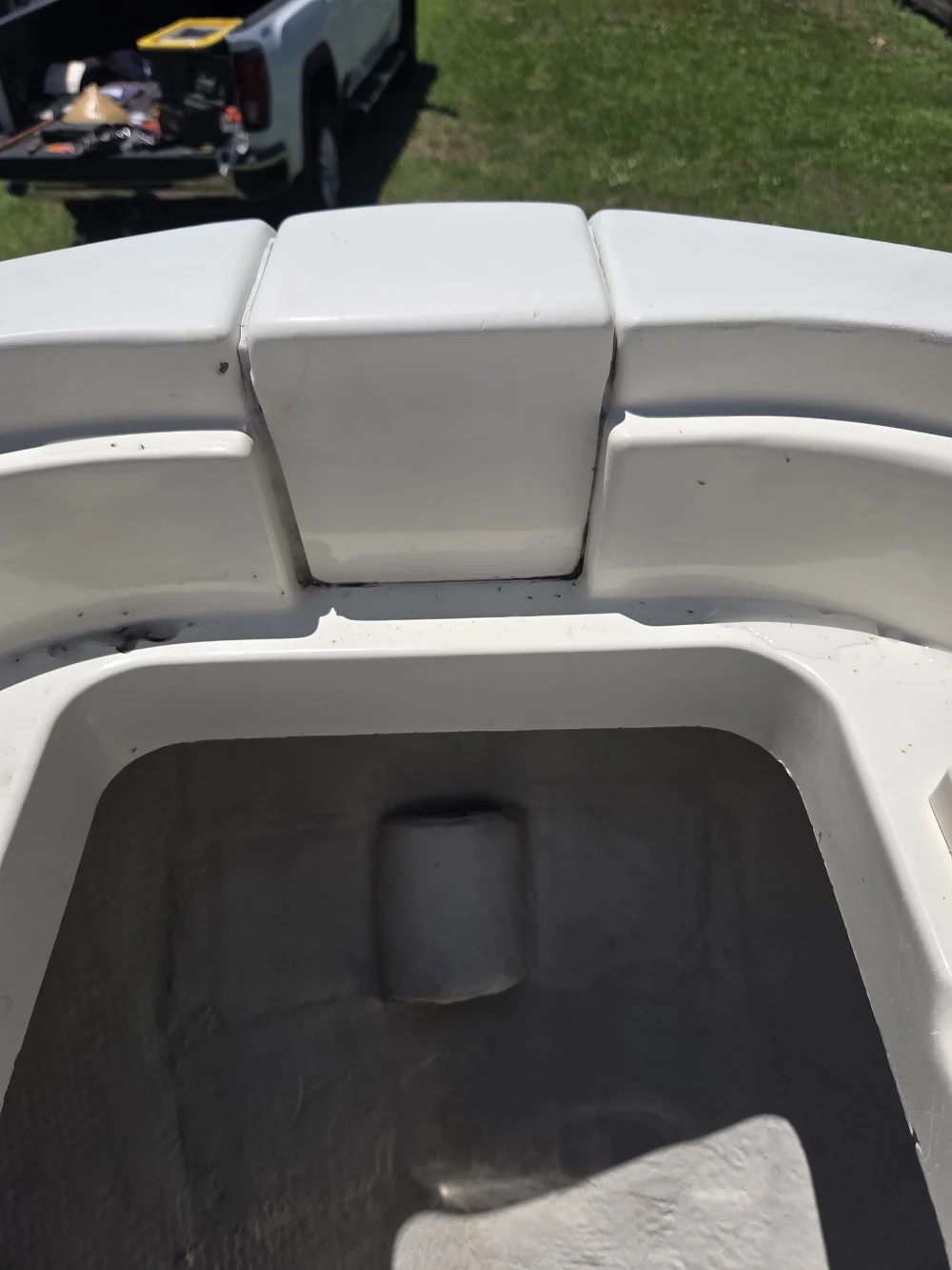 A white boat with the seat raised is serviced by Marine Kings of Miami with boat repair Miami.