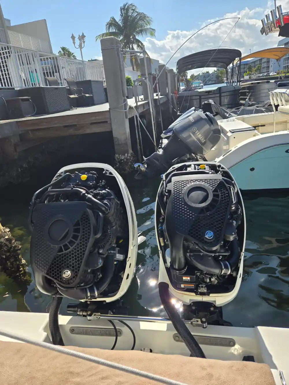 Two boats near a dock are serviced by Marine Kings of Miami with boat maintenance services.