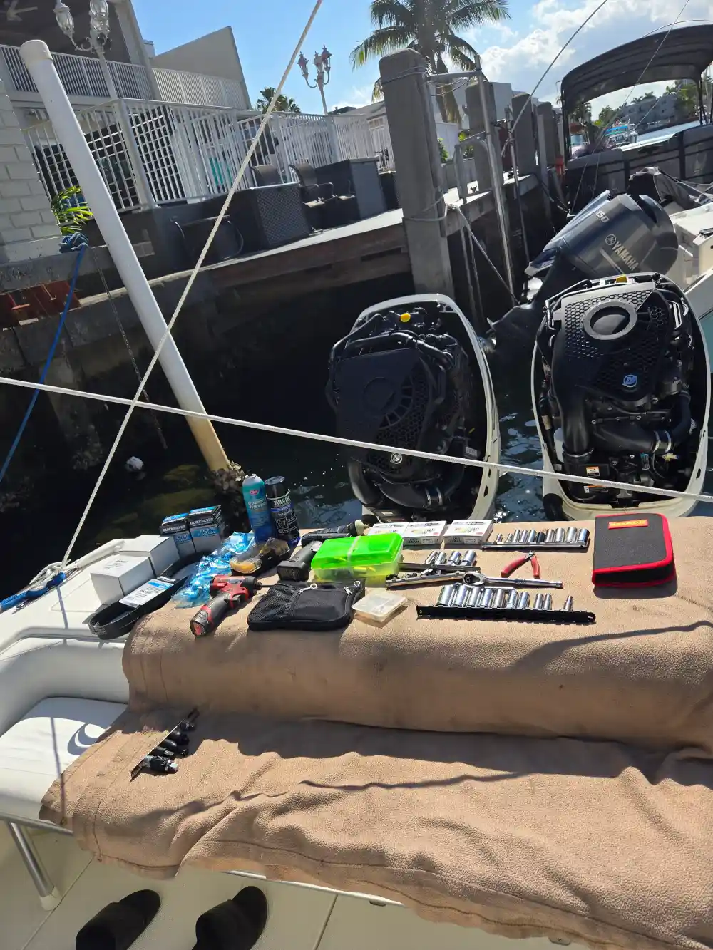 Seated at the back, a technician from Marine Kings of Miami works on boat maintenance services.