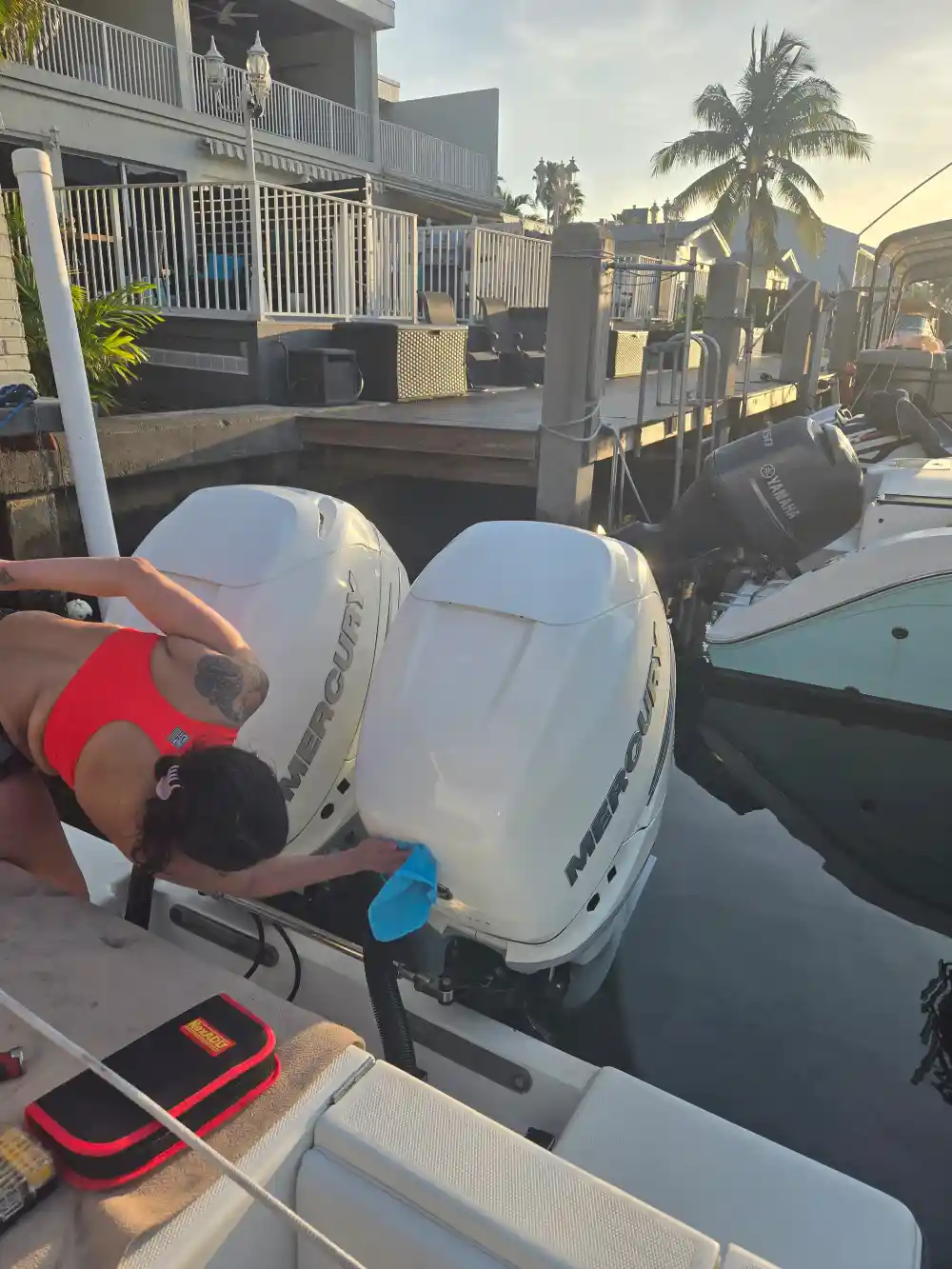 Leaning on a boat, a technician from Marine Kings of Miami prepares for maintenance services in Miami, Florida.