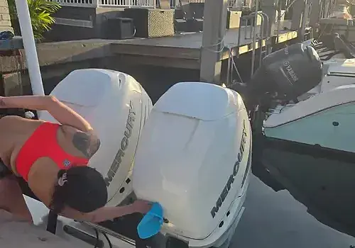 Leaning on a boat, a technician from Marine Kings of Miami prepares for maintenance services in Miami, Florida.