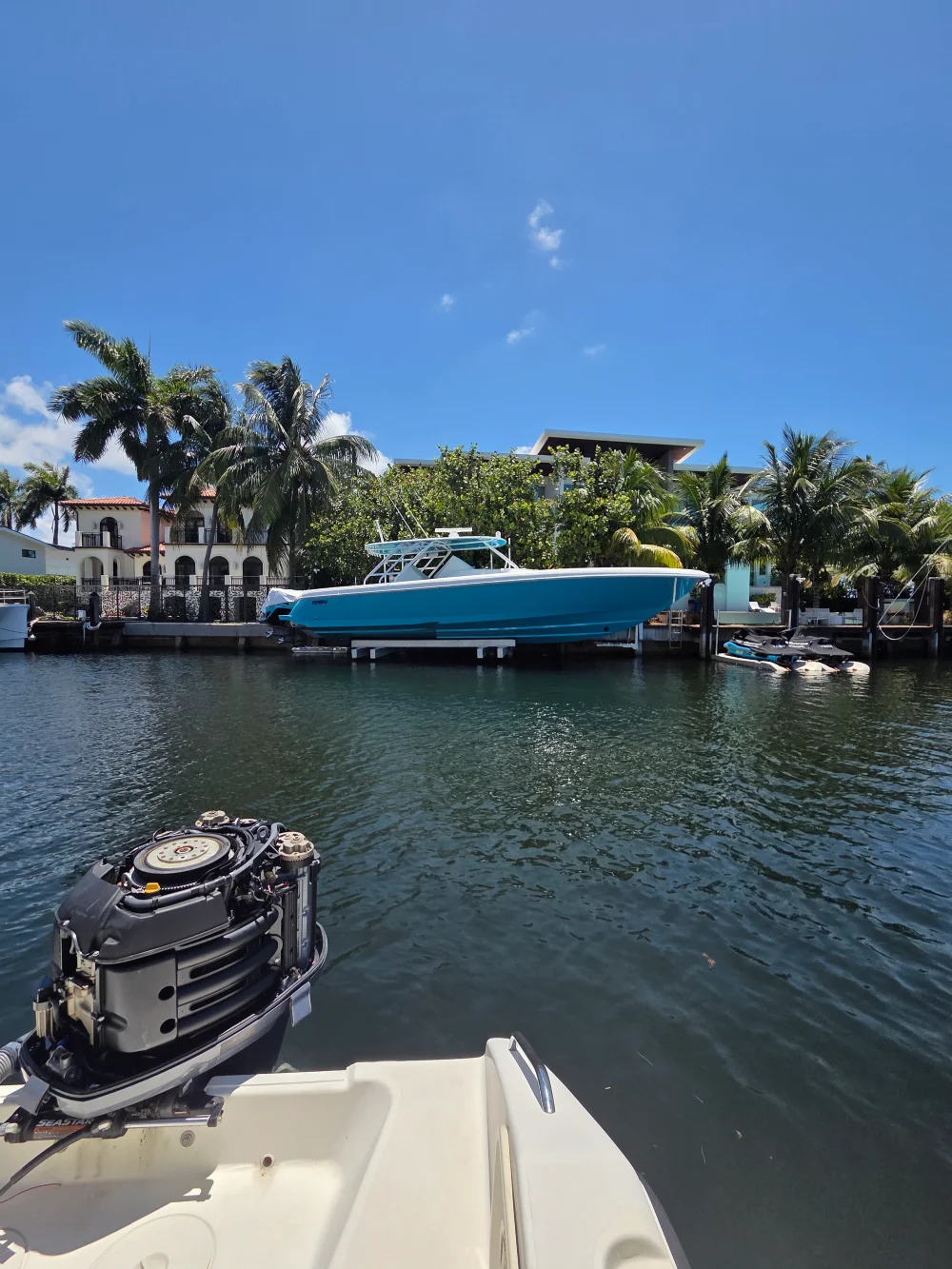  A docked boat near homes is serviced by Marine Kings of Miami with boat maintenance services.