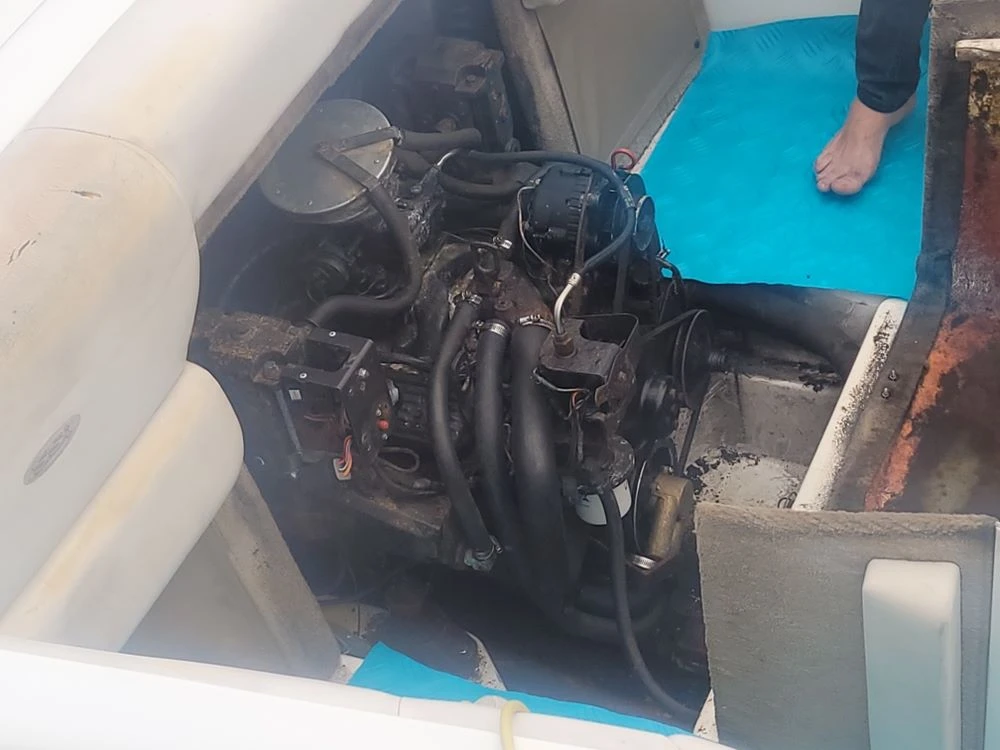 Standing beside a vessel, a technician from Marine Kings of Miami prepares for boat maintenance services.