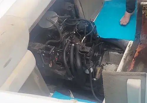 Standing beside a vessel, a technician from Marine Kings of Miami prepares for boat maintenance services.