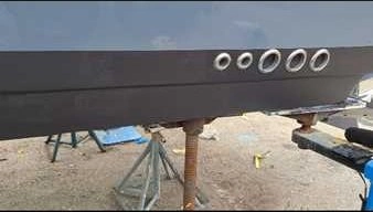 A black boat with wheels is handled by Marine Kings of Miami with boat maintenance services.