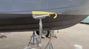 A boat parked on the beach is serviced by Marine Kings of Miami with boat maintenance services.