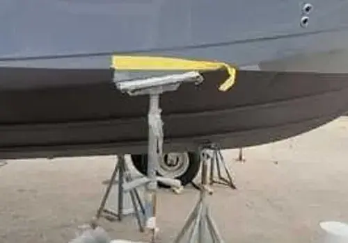 A boat parked on the beach is serviced by Marine Kings of Miami with boat maintenance services.
