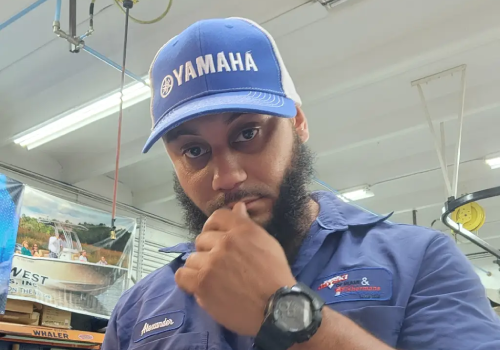 A blue cap worn by Alexander highlights boat maintenance services from Marine Kings of Miami in Miami, Florida.