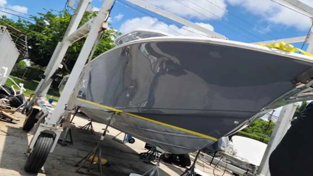 A trailer-towed vessel is transported by Marine Kings of Miami for boat maintenance services.