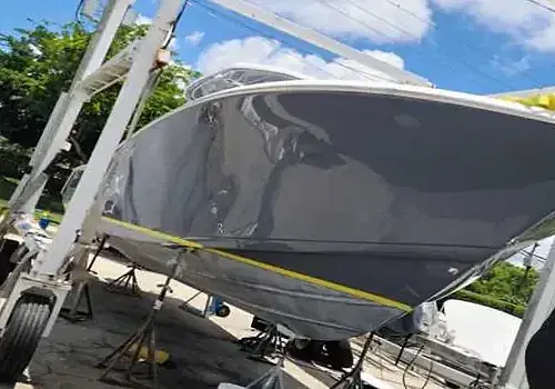 A trailer-towed vessel is transported by Marine Kings of Miami for boat maintenance services.