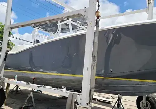 A boat is lifted by a crane as Marine Kings of Miami prepares it for boat repair Miami.