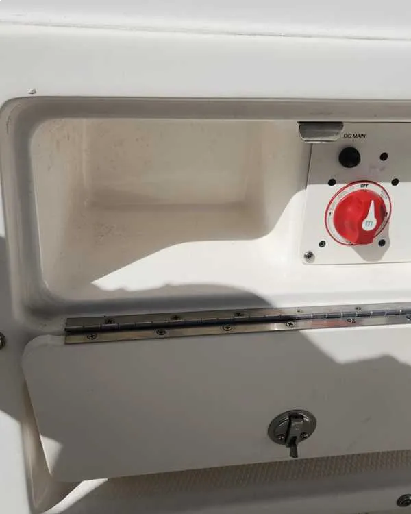 A boat door with a red button is serviced by Marine Kings of Miami with marine electrical troubleshooting.