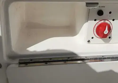 A boat door with a red button is serviced by Marine Kings of Miami with marine electrical troubleshooting.