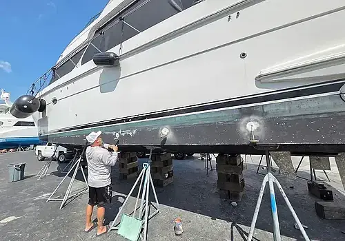  A technician working on the ground performs boat repair Miami for Marine Kings of Miami in Miami, Florida.