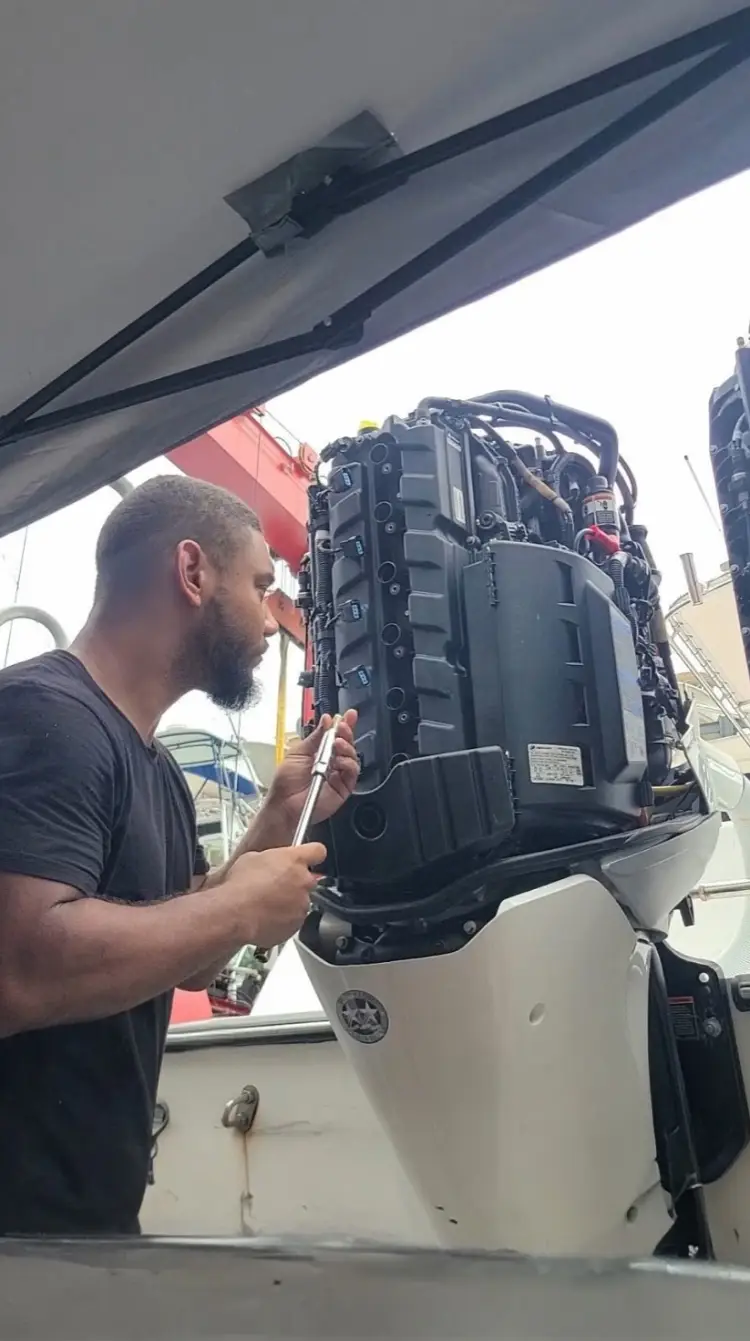 Engine work at the rear of the boat shows outboard engine service by Marine Kings of Miami.