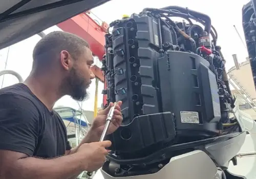  Engine work at the rear of the boat shows outboard engine service by Marine Kings of Miami.
