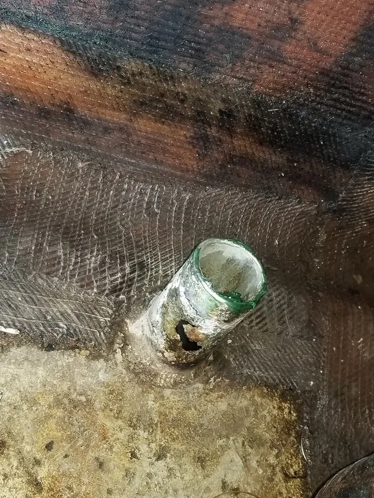  A bottle on the ground appears in a workspace used by Marine Kings of Miami for boat maintenance services in Miami, Florida.