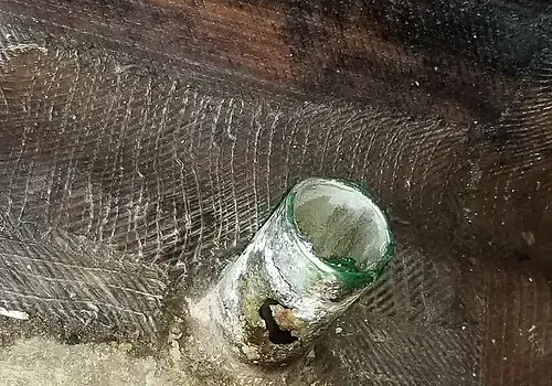  A bottle on the ground appears in a workspace used by Marine Kings of Miami for boat maintenance services in Miami, Florida.