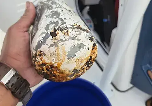 A handheld item is examined during marine engine diagnostics by Marine Kings of Miami.