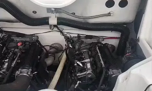  A white boat with dual engines is serviced by Marine Kings of Miami with outboard engine service.